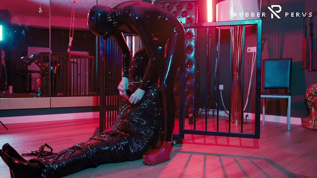 rubber nights: the rubber slave sleeps tight in a cage under the bed
