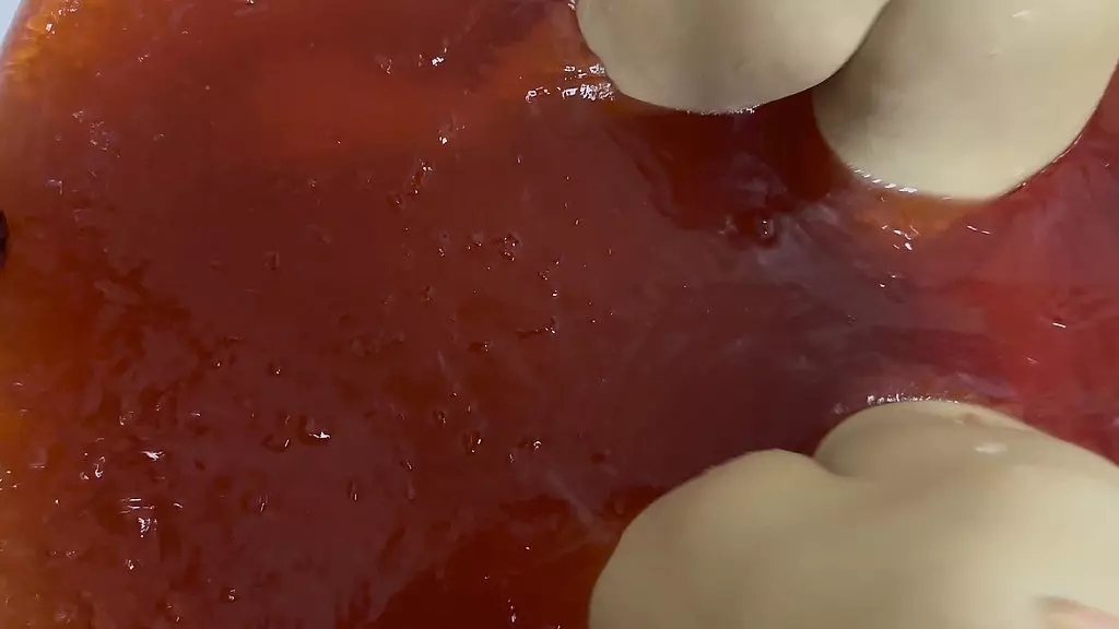 a bath in red coloured jelly cubes. as i scoop up the jelly cubes into a sieve, and empty them back over my body